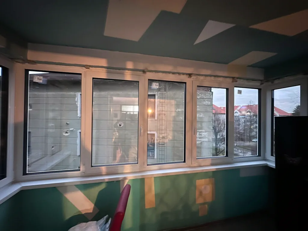 Patru ferestre PVC montate într-un balcon închis cu vedere spre exterior